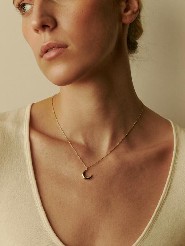 Model wearing a crescent pendant necklace