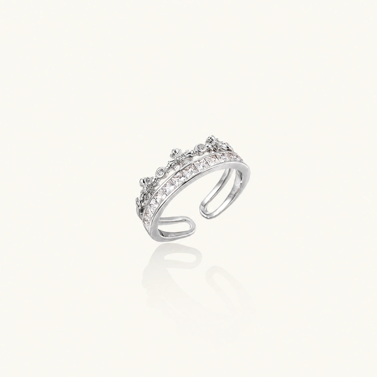 Royal Crown Ring: crown-shaped ring with princess-cut zirconia and small floral details across two bands