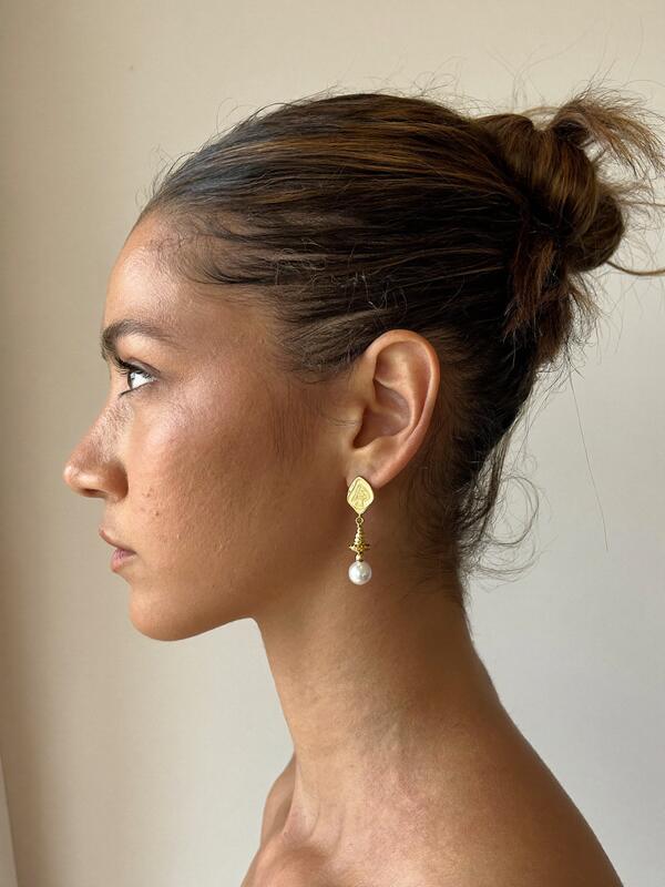 Model wearing pearl drop earrings